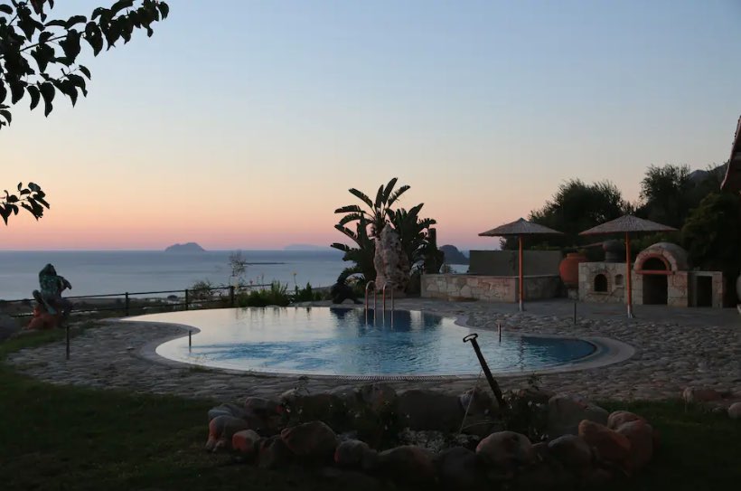 Pool and gardens at dusk over Aegean